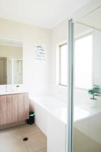 a white bathroom with a sink and a mirror at Entire house in Pimpama in Gold Coast