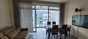 een woonkamer met een bank en een tafel met stoelen bij Apto Praia Gonzaga - melhor localização in Santos