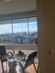 balcone con sedie e vista sulla città di Aluguel de quarto a Torres