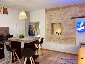 uma cozinha com uma parede de pedra e um bar num quarto em LA MARIEFACTURE - Comme un Art de Rire em Belleville