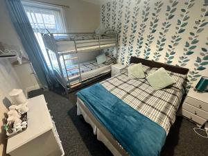 ein Schlafzimmer mit einem Bett und einem Etagenbett in der Unterkunft Greenmount Guest House - Pet Friendly - Central to Everything - Everyone Welcome in Blackpool