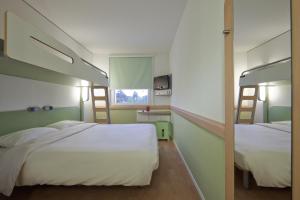 Postel nebo postele na pokoji v ubytování ibis budget Basel Pratteln