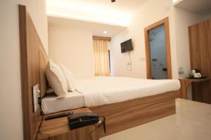 Habitación de hotel con cama y TV en Hotel Shanti International en Deoghar