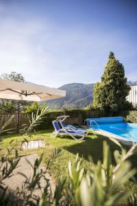 a swimming pool with an umbrella next to a swimming pool at Sonnenberg in Silandro