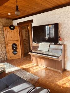 un piano en una habitación con una pared y TV en LA MARIEFACTURE - Comme Si comme Fa en Sarreguemines