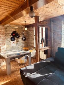 ein Wohnzimmer mit einem Tisch und einer Steinmauer in der Unterkunft LA MARIEFACTURE - Comme Si comme Fa in Sarreguemines