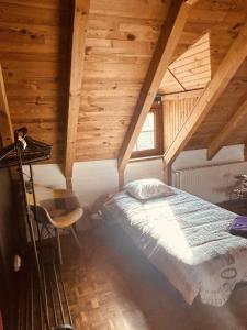 1 dormitorio con 1 cama en una habitación con techos de madera en LA MARIEFACTURE - Comme Si comme Fa en Sarreguemines