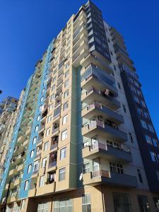 Un edificio alto de apartamentos con gente en los balcones. en Двухкомнатная кватира с видом на горы, en Batumi