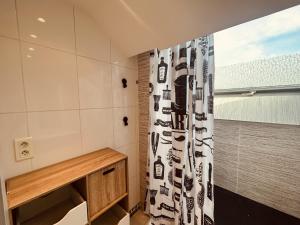 a bathroom with a shower with a black and white shower curtain at LA MARIEFACTURE - Comme à la Montagne in Faulquemont
