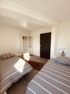1 Schlafzimmer mit 2 Betten und einer schwarzen Tür in der Unterkunft LA MARIEFACTURE - Comme à la Farandole in Farébersviller