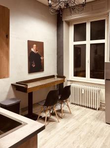 eine Küche mit einem Tisch und einem Bild eines Mannes an der Wand in der Unterkunft LA MARIEFACTURE - Comme une Forteresse in Neuf-Brisach