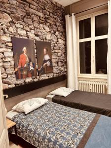 sypialnia z 2 łóżkami i kamienną ścianą w obiekcie LA MARIEFACTURE - Comme une Forteresse w mieście Neuf-Brisach