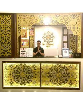 a man is standing behind a counter in a store at Le Maroc Hotel Patong in Patong Beach