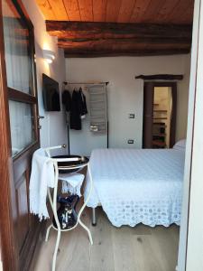 1 dormitorio con cama, mesa y armario en Appartamento Su Piricocco - La casa dei ricordi en Triei