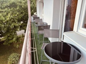 balcón con sillas, mesa y ventana en LA MARIEFACTURE - Comme une Fleur, 