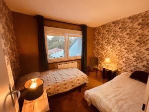 a bedroom with two beds and a window at LA MARIEFACTURE - Comme une Fleur 