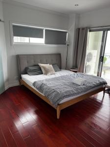 A5U3 Hostel في غولد كوست: سرير كبير في غرفة نوم مع أرضية خشبية