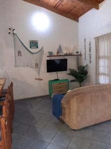 sala de estar con sofá y TV de pantalla plana en Beach Cottage - Hole in the Wall Resort, en Hole in the Wall