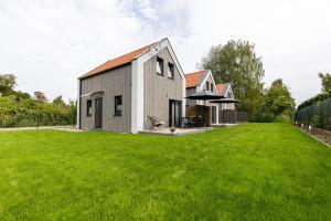 ein Haus mit einem großen Garten mit grünem Rasen in der Unterkunft Solo na wyspie, blisko morza Sobieszewo in Danzig