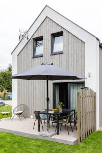 ein Tisch mit Sonnenschirm vor einem Haus in der Unterkunft Solo na wyspie, blisko morza Sobieszewo in Danzig
