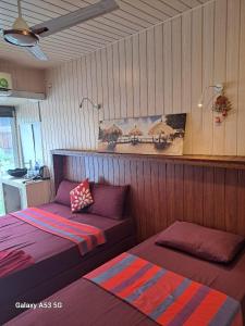 two beds in a room with wooden walls at THE WISH RESIDENCE BEACH SIDE KOLUPITIYA Colombo 3 in Colombo