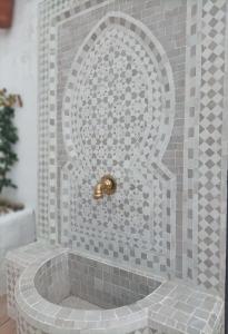 y baño con ducha y pared de mosaico. en Casa Celeste Trabuco, en Villanueva del Trabuco