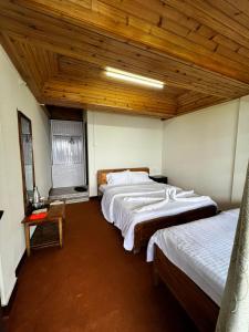 een slaapkamer met 2 bedden en een houten plafond bij Yankee Village Retreat, Rishop in Rishop
