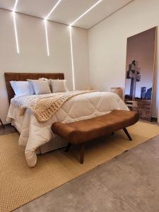 Un dormitorio con una cama grande y un banco en Pousada das Missoes en São Miguel das Missões