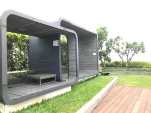 een zwart gebouw met een bank op het gras bij Sukhumvit 48 BTS Phra khanong 1 Bedroom Apartment, Gym, Swimming pool in Bangkok