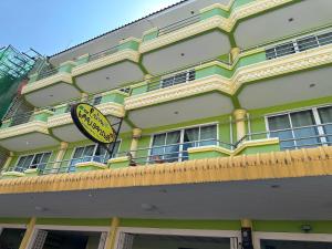 a yellow and green building with a sign on it at Baan Keang Talay Cha Am in Cha Am
