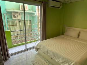 1 dormitorio con cama y ventana grande en Baan Keang Talay Cha Am, en Cha Am