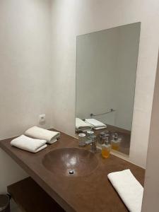 a bathroom with a sink and a large mirror at Villa Le Petit Paradis Saly Boutique Hotel in Ngaparou