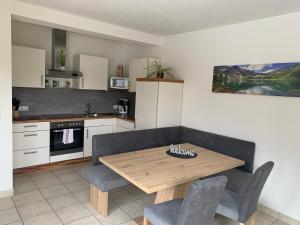 eine Küche mit einem Holztisch und 2 Stühlen in der Unterkunft Appartement Alexandra in Flattach