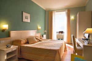 1 dormitorio con 1 cama en una habitación con ventana en Hotel Belvedere San Gottardo en Verbania