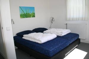 Una cama con dos almohadas encima. en Lamsoor 14*, en Nieuwvliet