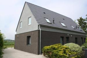 una casa de ladrillo con techo de gambrel en Lamsoor 14*, en Nieuwvliet