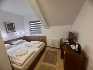 a bedroom with a bed and a desk with a television at Aqua terme Palic in Palić