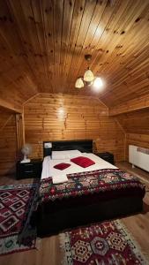 a bedroom with a bed in a wooden room at Pensiunea IULIA in Rod