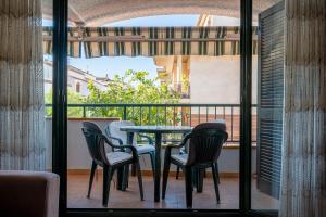 een patio met een tafel en stoelen op een balkon bij AT044 Els Porxos in Torredembarra