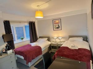 a bedroom with two beds and a desk and a window at The Horse & Jockey in Gainsborough