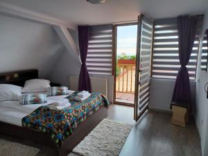 a bedroom with a bed and a large window at Pensiunea IULIA in Rod