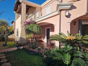 ein Haus mit einer Veranda und einem Innenhof mit Pflanzen in der Unterkunft Casa Vacanze Estate Al Mare in Tortolì