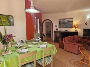 ein Wohnzimmer mit einem Tisch und einem Sofa in der Unterkunft Casa Vacanze Estate Al Mare in Tortolì