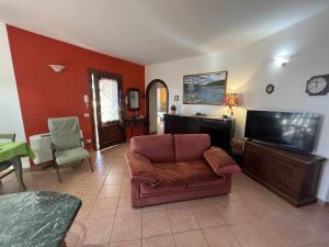 ein Wohnzimmer mit einem Sofa und einem Flachbild-TV in der Unterkunft Casa Vacanze Estate Al Mare in Tortolì