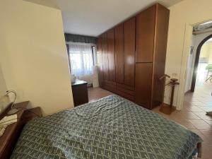 Schlafzimmer mit einem Bett und einem Holzschrank in der Unterkunft Casa Vacanze Estate Al Mare in Tortolì