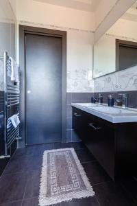 La salle de bains est pourvue d'un lavabo et d'un grand miroir. dans l'établissement SuiteHouse - Jacuzzi & Comfort, à San Giorgio a Cremano