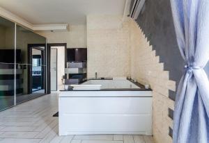 une cuisine avec une grande baignoire blanche et un mur en briques dans l'établissement SuiteHouse - Jacuzzi & Comfort, à San Giorgio a Cremano
