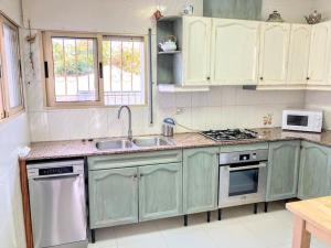 a kitchen with green cabinets and a stove top oven at Casa Cristina in Vinarós