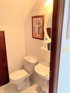 a white bathroom with a toilet and a sink at Casa Cristina in Vinarós