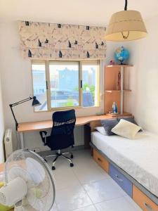 een slaapkamer met een bureau en een bed met een ventilator bij Casa Cristina in Vinarós